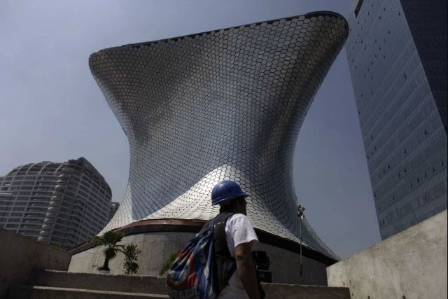 A worker walks in front of the Soumaya Museum's new home in Mexico City, Tuesday March 1, 2011. The new building, which will be inaugurated Tuesday evening by Mexico's President Felipe Calderon and opened to the general public on March 29, will house Mexican billionaire Carlos Slim's fast-growing collection of art objects. (AP Photo/Dario Lopez-Mills)