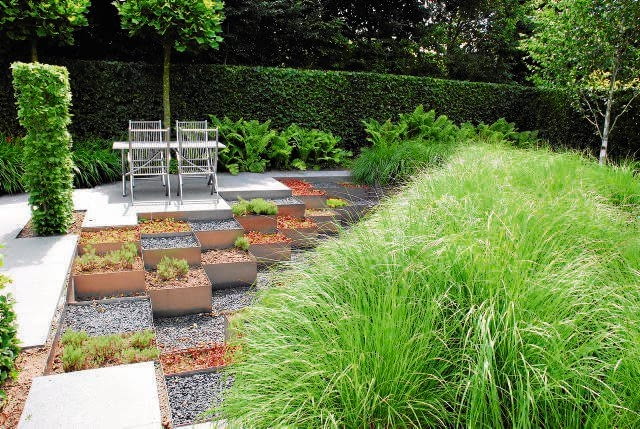 SKARPA W KASETONACH Pochyłości terenu często obsiewamy trawą. Poniżej prezentujemy ciekawsze i bardziej praktyczne rozwiązanie (trawnik na skarpie często trudno kosić). Zamiast murawy zastosowano tutaj metalowe kasetony, pełniące funkcję umocnienia i zarazem donic dla roślin. Można je wypełnić dowolną ziemią i uprawiać rośliny o różnych wymaganiach glebowych - to dodatkowy plus tego wariantu.