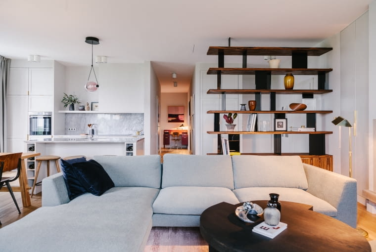 Strefa jadalniano-wypoczynkowa jest spójna pod względem stylistycznym i kolorystycznym: dominują delikatne szarości i mocniejsze akcenty.