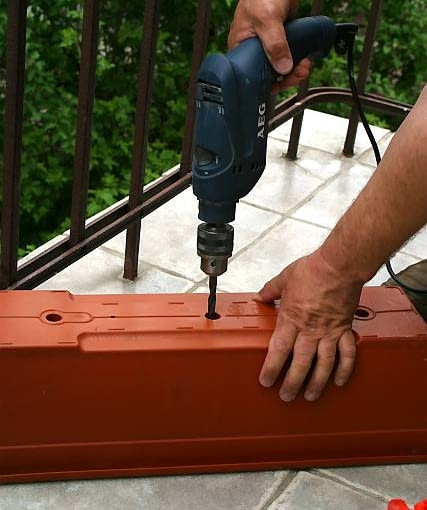 09.05.2003 WARSZAWA BALKON ROSLINY SADZENIE PRZYGOTOWANIE SKRZYNKI BALKONOWEJ SKRZYNKA BALKONOWA WIERCENIE OTWORY ODPLYWOWE DO WODY PLASTIK WIERTARKA CZLOWIEK