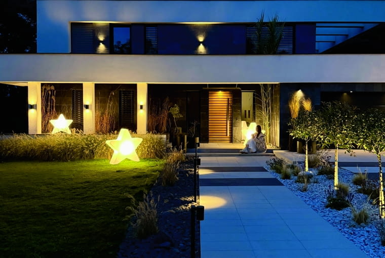 Zgodnie z koncepcją inwestorów, głównym akcentem ogrodowym jest rozległy trwanik, ale przed wejściem do domu postanowili oni jednak co nieco dosadzić – i oczarować klimatem