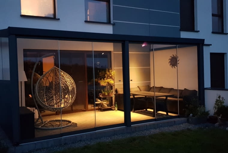 Profiline 6x2,5m z boczną ścianą z paneli i poliwęglanu oraz drzwi przesuwne nocą Profiline 6x2,5m z boczną ścianą z paneli i poliwęglanu oraz drzwi przesuwne nocą