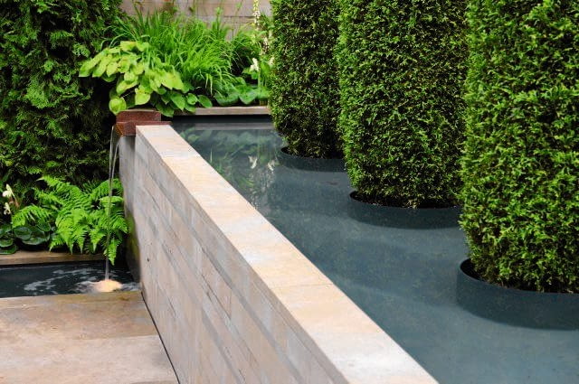 TARASY WODNE Tarasy wodne zamiast ziemnych? Czemu nie! Ten pomysł warto polecić zwłaszcza właścicielom ogródków położonych na skarpach, marzących o własnym stawie i kojącym plusku wody. Tutaj przelewa się ona małą kaskadką z wyższego, płaskiego zbiornika do niewielkiej misy umieszczonej poniżej. Woda krąży w obiegu zamkniętym - pompa ulokowana w niższym zbiorniku tłoczy wodę ukrytymi przewodami na wyższy poziom, skąd spływa na dół. I cykl się powtarza...