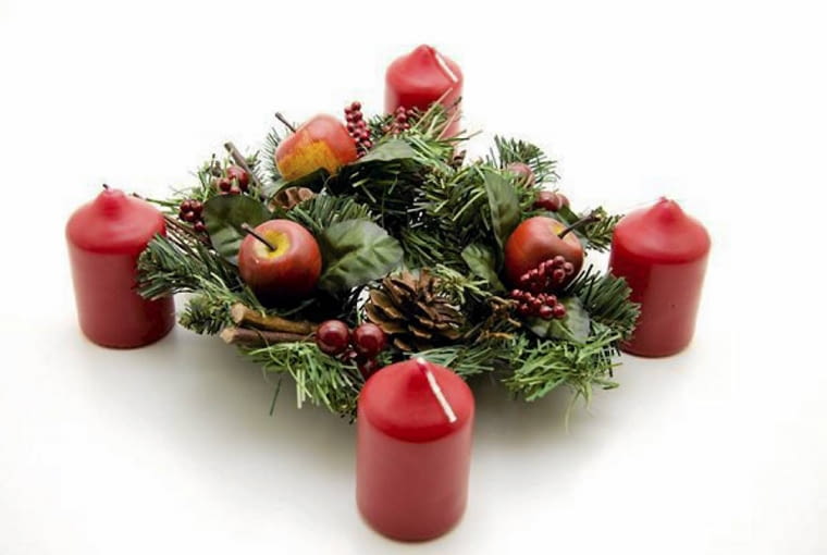 Ozdoby adwentowe. Wieniec z jabłkami i świecami postawionymi na zewnątrz
