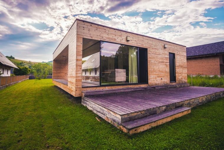 Domy drewniane najczęściej kojarzą się nam z tradycyjną architekturą. Tymczasem spotkamy je też w nowoczesnej odsłonie – prostej, oszczędnej, pozbawionej detali formie