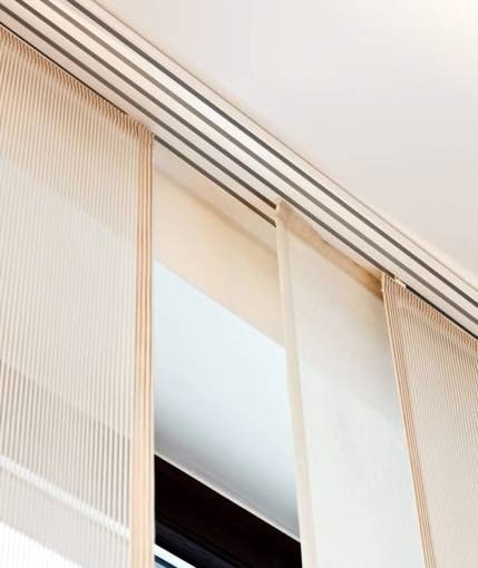 DEKORACJE - OKNA DYSKRETNIE PRZESŁONIĘTE. Panele przesuwają się na boki po specjalnych prowadnicach - szynach zamontowanych na suficie. Ich liczba odpowiada liczbie paneli.