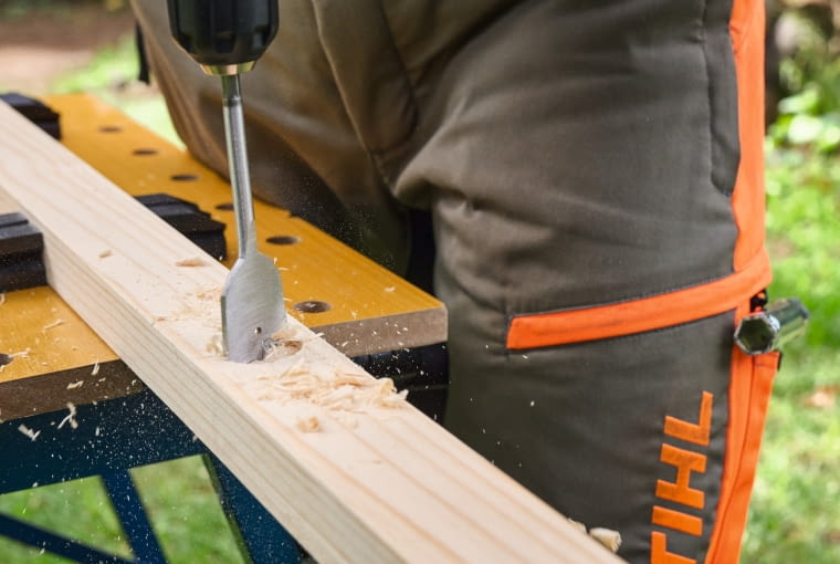 Krok 3. Wykonaj otwory Przed wywierceniem otworów na łączące drewno śruby należy zaznaczyć ich miejsce: zgodnie z rysunkiem konstrukcyjnym. Do zrobienia otworów nieprzelotowych nadaje się wiertło Forstnera o średnicy 35 mm, a do otworów przelotowych – wiertło do drewna o średnicy 10 mm. Koniecznie wywierć nieprzelotowe otwory na śruby – czyli takie, które nie tworzą prześwitu, a wkręt nie przechodzi całkowicie przez element. Zapobiega to późniejszemu zahaczeniu pilarką łańcuchową o łączenia.