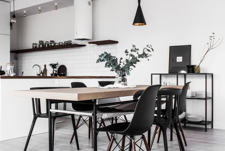 Prosty stół przybrany zestawem różnych krzeseł jest na tyle duży, że z powodzeniem zmieści rodzinę i gości. Jego lekki blat wykonano z korka (seria Sinnerlig). Nad nim blikują czarno-złote lampy z kolekcji Pedro.