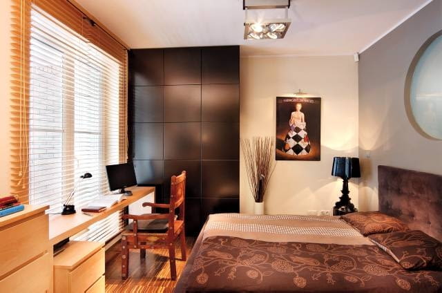 W drzwiach balkonowych w sypialni, która w dzień zamienia się w gabinet, żaluzje są rozwiązaniem idealnym. Można nimi całkowicie zasłonić okno albo wpuścić do środka tyle naturalnego światła, ile właśnie potrzeba. Są też dekoracją bardziej neutralną niż zasłony. <BR />DEKORACJE - OKNO Z DREWNIANĄ ŻALUZJĄ. Drewniane żaluzje pełnią tutaj głównie praktyczną funkcję - w ciągu dnia pozwalają decydować o mocniejszym lub słabszym oświetleniu wnętrza.