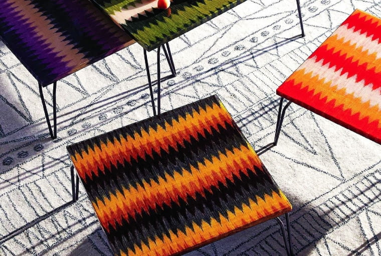 Barwne stoliki - blaty z utwardzonych żywicą włókien bananowca. Wykonane przez artystów z Filipin, Anthropologie.