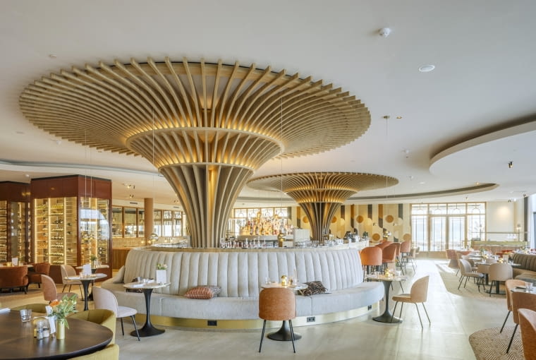 Biel na stropie wnętrz współgra z jasnymi sofami, ma też za zadanie chłodzić nieco miodowo-złoty wystrój pomieszczeń Biel na stropie wnętrz współgra z jasnymi sofami, ma też za zadanie chłodzić nieco miodowo-złoty wystrój pomieszczeń