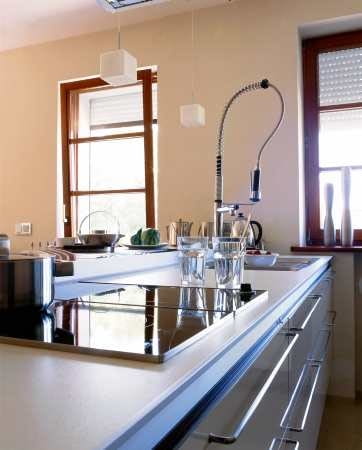 Zabudowa tworząca kuchenną wyspę jest zrobiona z takiego samego drewna jak meble w salonie. Dzięki temu wnętrza stanowią jednolitą stylistycznie całość.