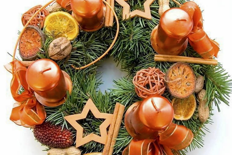Ozdoby adwentowe. Wieniec z suszonymi plastrami pomarańczy, laskami cynamonu, orzechami, wstążkami i drewnianymi gwiazdkami