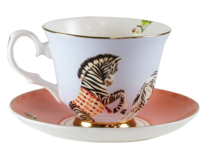 Filiżanka ze spodkiem Carnival Zebra. Kombinacja malowanych ręcznie przez Yvonne Ellen zwierząt, w stylu retro z kolorami vintage, nawiązuje do klasyki, ale jest przy tym bardzo nowoczesna. W kolekcji znajdziemy również naczynia rysunki tygrysa, żyrafy, flaminga, jamnika, papugi i niebieskiej rybki. Wymiary: 8 x 14 cm. Materiał: porcelana kostna. Cena: 99 zł. Do kupienia na www.lapomme.pl Filiżanka Yvonne Ellen