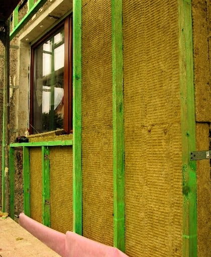 Pierwsza warstwa wełny pod rusztem drewno na elewacji