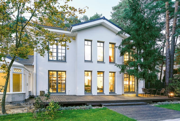 Od strony ogrodu dom uzupełniono rozległym, drewnianym tarasem wypoczynkowym Od strony ogrodu dom uzupełniono rozległym, drewnianym tarasem wypoczynkowym