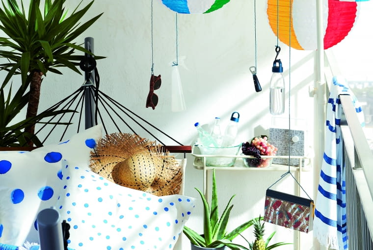 Hamak zaprasza nie tylko do lektury – na takich poduszkach możemy pośnić o wakacjach; barwne lampiony rozweselają przestrzeń.