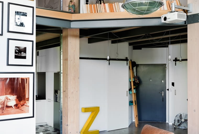 Otwarta antresola pozwala spojrzeć na salon z góry. Nad kanapą solidna lampa ORP 250 ze starej fabryki na Woli. Dywan-patchwork upolowany na Allegro. Otwarta antresola pozwala spojrzeć na salon z góry. Nad kanapą solidna lampa ORP 250 ze starej fabryki na Woli. Dywan-patchwork upolowany na Allegro.