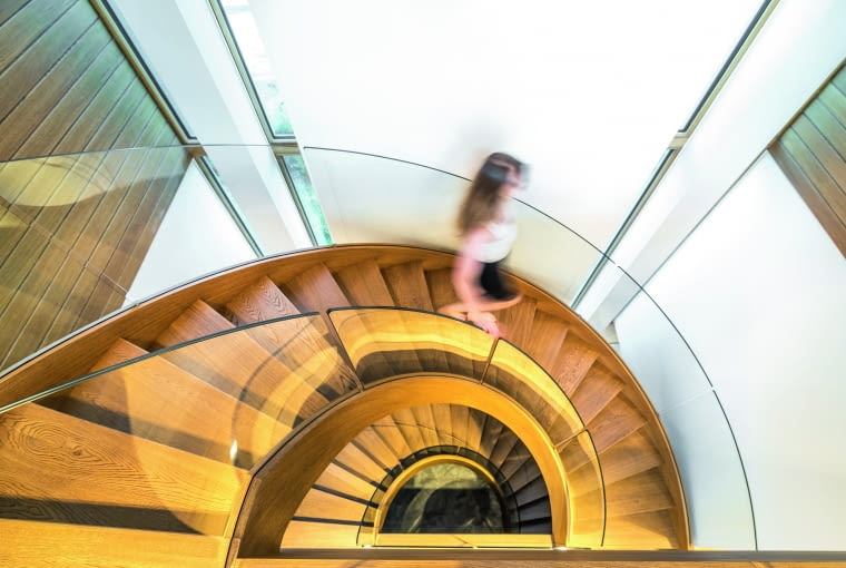 Podobne skojarzenia z wysokiej klasy architekturą miejską rodzi spojrzenie z góry w dół tego imponującego ciągu schodów, będącego w istocie rodzajem klatki schodowej. Spiralne zejście zabezpieczono szklanymi balustradami, które korespondują z tymi zamykającymi balkony piętra Podobne skojarzenia z wysokiej klasy architekturą miejską rodzi spojrzenie z góry w dół tego imponującego ciągu schodów, będącego w istocie rodzajem klatki schodowej. Spiralne zejście zabezpieczono szklanymi balustradami, które korespondują z tymi zamykającymi balkony piętra