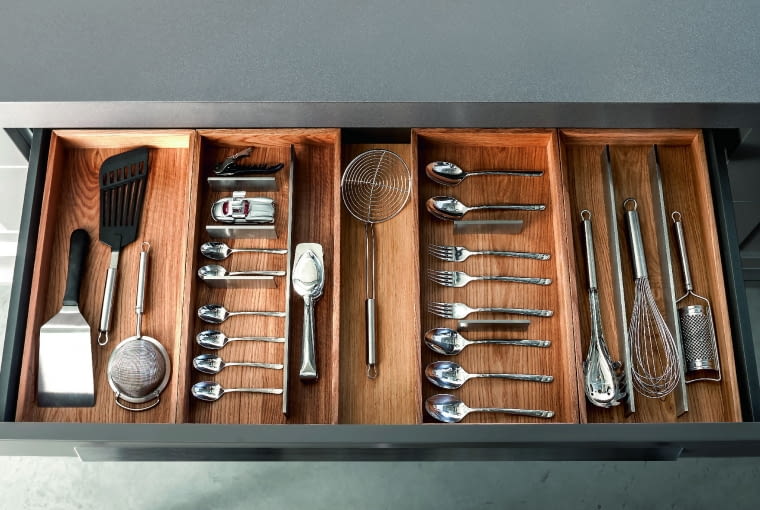 Wszystko pod ręką Firma Zajc Kuchnie do wszystkich swoich modeli wyposażonych w szufladę Hettich ArciTech wprowadziła innowacyjne organizery. Dzięki szachownicy żłobień, w którą można wsuwać różnej długości stalowe przegródki, potrzebne akcesoria zawsze są na swoim miejscu. Cena zależy od wymiarów i wykończenia, Zajc Kuchnie, www.meble-zajc.pl