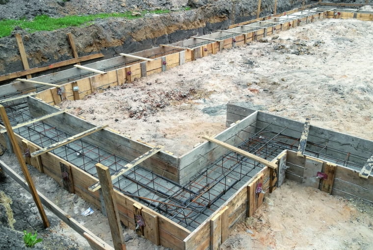 Fundamenty robi się z betonu zbrojonego stalowymi prętami. Podczas zbrojenia fundamentów trzeba kierować się ogólnymi zasadami wykonywania elementów żelbetowych Fundamenty robi się z betonu zbrojonego stalowymi prętami. Podczas zbrojenia fundamentów trzeba kierować się ogólnymi zasadami wykonywania elementów żelbetowych