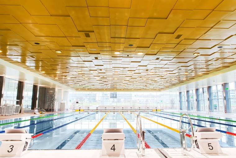 Nad całą powierzchnią 50 metrowego basenu olimpijskiego i powierzchni sąsiadującej z niecką basenową zawisło w sumie 1,5 tys. m2 złotych płyt Nad całą powierzchnią 50 metrowego basenu olimpijskiego i powierzchni sąsiadującej z niecką basenową zawisło w sumie 1,5 tys. m2 złotych płyt