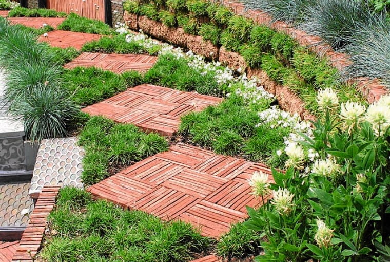 OGRODOWY PARKIET z ułożonych na trawie paneli z drewnianych listewek.