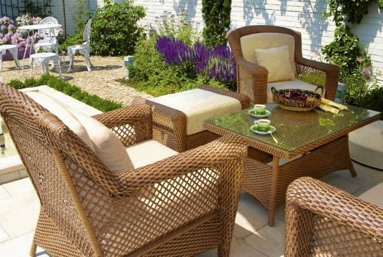 Na tarasie ustawiono okazałe meble z rattanu, a na placyku - finezyjne z żeliwa Na tarasie ustawiono okazałe meble z rattanu, a na placyku - finezyjne z żeliwa