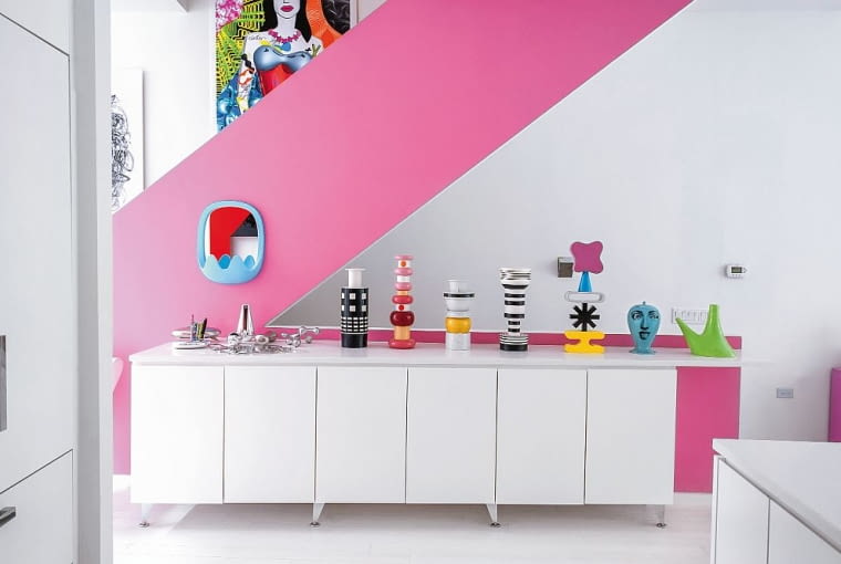Fragment salonu. Schody wykorzystane jako nośnik energetycznego różu. Na balustradzie lustro Oskar z praktyczną półką i haczykami. Karim Rashid, wnętrza, desig