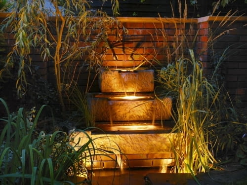 Kaskada wodna oświetlona reflektorami osadzonymi w jej stopniach.