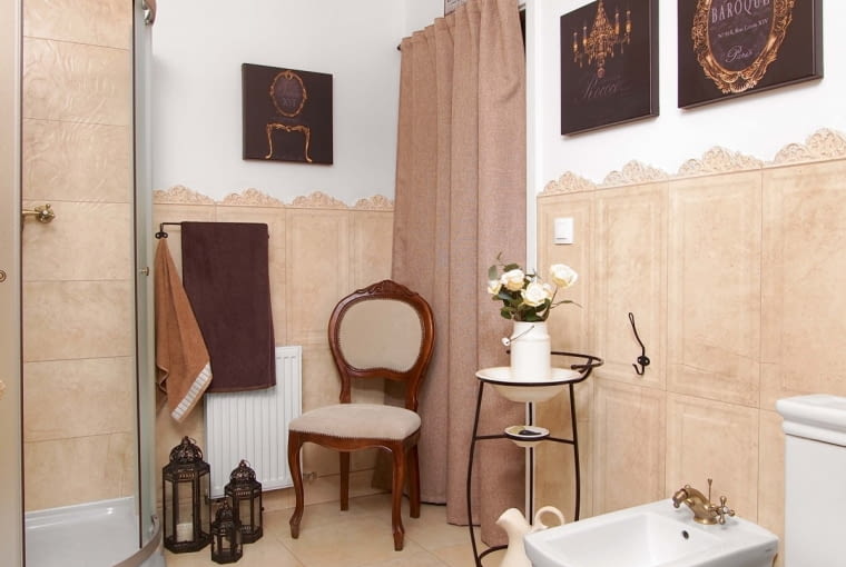 Za ciężką kotarą jest ukryte wejście do pralni. Krzesło z aukcji internetowej przyjechało w tak opłakanym stanie, że Ania pożałowała zakupu. Udało się je jednak odnowić. Uwagę zwraca zestaw toaletowy retro kupiony na targu staroci.