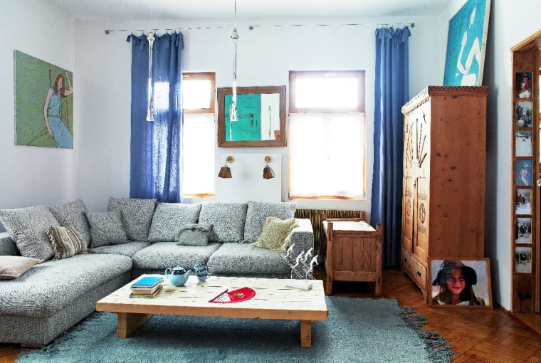 RZEŹBIONA GÓRALSKA SZAFA i ręcznie tkany dywan dobrze wyglądają obok prostej kanapy nawiązującej do skandynawskiego designu (BoConcept) i nowoczesnych lamp w kształcie sopli lodu (projekt Jeremiego Nagrabeckiego).
