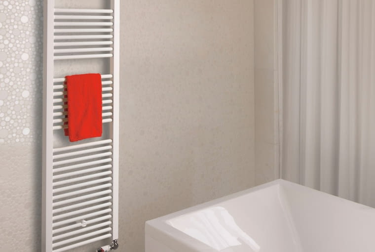 Klasyczna biała drabinka łazienkowa z większymi przerwami pomiędzy kolejnymi rzędami poziomych profili. Pozwala to wygodnie  powiesić wilgotny ręcznik i zdjąć go po wysuszeniu