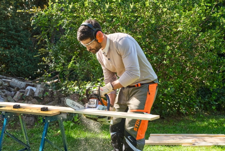 Krok 2. Przytnij i wyszlifuj drewno Najpierw sprawdź napinacz łańcucha i poziom oleju w pilarce. Teraz przytnij drewniane części koziołka i zeszlifuj krawędzie po cięciu. Zachowaj szczególną ostrożność, ponieważ cięcie może spowodować powstawanie odprysków.