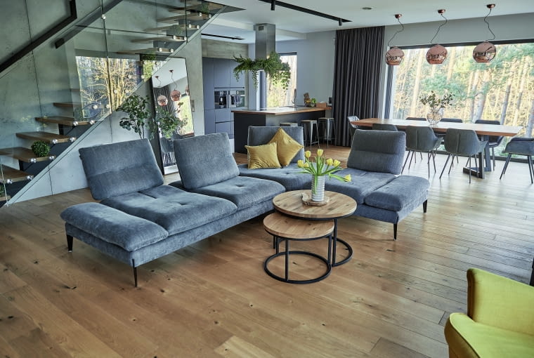 „Naszym ulubionym miejscem jest oczywiście strefa dzienna – salon i jadalnia. To prawdziwe serce naszego domu. Tu znajduje się też najpiękniejszy element w budynku – lekkie i zgrabne schody, ze szklaną balustradą dopełniającą efekt wizualny."