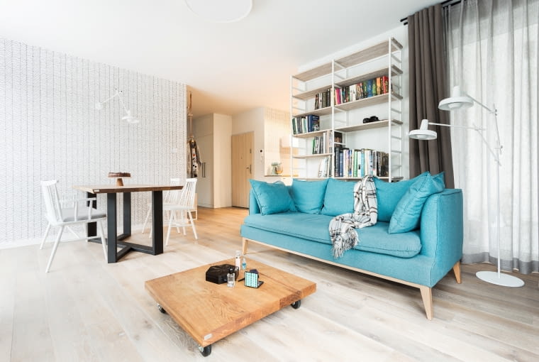 W salonie główną rolę odgrywa sofa w wyszukanym, błękitnym odcieniu. Cozy Nordic Home czyli przytulne mieszkanie z kotem w tle