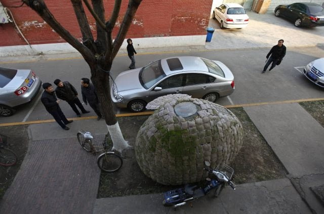 Dai Haifei's egg-shaped mobile house is seen near his office building in Beijing December 3, 2010. Dai, who is from central China's Hunan province and cannot afford Beijing's high rental prices, has been living in the house which costs about 6427 yuan ($965). The house is made of bamboo strips, steel bars, heat prevention and waterproof materials, sacks filled with fermented wood chips and grass seeds, as well as one solar-cell panel, local media reported. REUTERS/Petar Kujundzic (CHINA - Tags: BUSINESS SOCIETY)