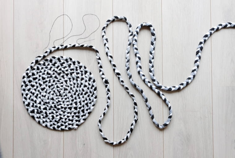 KROK 3. Gdy warkocz osiągnie już wymaganą długość, zaczynamy modelować podkładkę. Zwijamy warkocz, jednocześnie zszywając nitką sąsiadujące ze sobą warstwy  aż do uzyskania koła odpowiedniej wielkości. Z resztek warkocza możemy zrobić rączki do torby. KROK 3. Gdy warkocz osiągnie już wymaganą długość, zaczynamy modelować podkładkę. Zwijamy warkocz, jednocześnie zszywając nitką sąsiadujące ze sobą warstwy  aż do uzyskania koła odpowiedniej wielkości. Z resztek warkocza możemy zrobić rączki do torby.