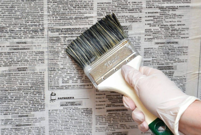 KROK 4. 'Tapetę' zabezpieczamy, pokrywając jej wierzch klejem (przy okazji ją wygładzamy). Szczególnie starannie smarujemy miejsca na styku kartek. Na koniec zdejmujemy taśmę.