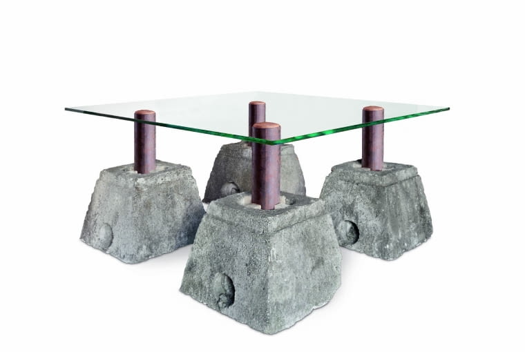 Stół z upcyklingowej kolekcji marki Nizio Interior został zaprojektowany przez architekta Mirosława Nizio. Blat z hartowanego szkła opiera się na masywnych nogach ze stalowych rur i podstawie z czterech betonowych bloków. niziointerior.pl