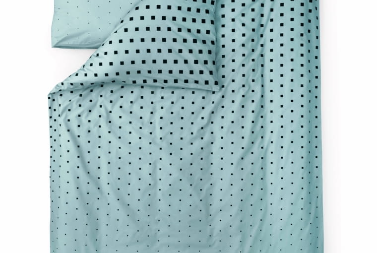 normann copenhagen Małe kwadraciki, które stopniowo blakną aż do całkowitego zaniknięcia to efektowny pomysł duńskiej marki. Uszyta z bawełny w kolorach pastelowego błękitu z domieszką mięty. Wym. 140 x 200 cm; 60 x 63 cm, fabrykaform.pl, 318 zł