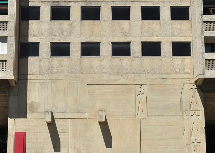 Jednostka Marsylska, proj. le Corbusier - detale na dziedzińcu wschodnim. Od lewej - "stela miar" odzwierciedlająca dwie serie Modulora, ławka, kamień węgielny. Na fasadzie budynku widoczne okno z foyer, oraz sylwetki nazwane przez Le Corbusiera "Widmami Modulora"