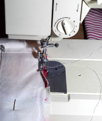 5. Wystające po bokach zapasy zakładamy na brzegi rolety i przeszywamy zwykłym ściegiem.