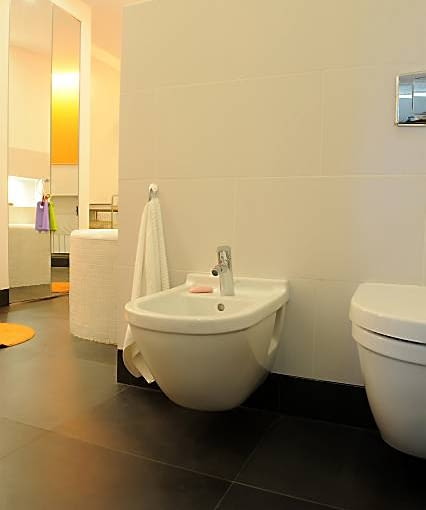 Strefa sanitarna jest wyraźnie oddzielona od kąpielowej - na ich granicy znajduje się ścianka obłożona płytkami gresu. Taki sam materiał, tylko w innym kolorze, położono na podłodze.