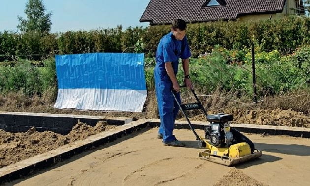 Następnie dokładnie się ją zagęszcza; jeśli ma być wykonana podsypka, nawozi się piasek i ubija go warstwami Następnie dokładnie się ją zagęszcza; jeśli ma być wykonana podsypka, nawozi się piasek i ubija go warstwami