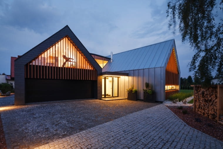 Klasyczny, dwuspadowy dach, a pod nim wnętrze pełne nowoczesnego wzornictwa. Ciekawa architektonicznie fuzja znanych form z nowymi rozwiązaniami. dom w tychach, dom stodoła, dom w stodole, nowoczesny dom