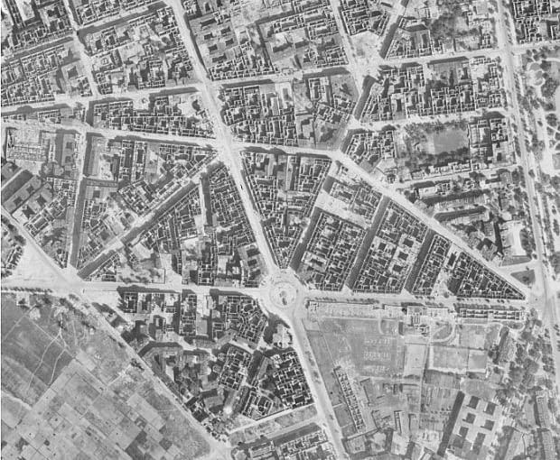 Zdjęcie lotnicze z 1945 roku. Obszar śródmieścia Warszawy, który przeznaczono na realizację Marszałkowskiej Dzielnicy Mieszkaniowej, z przedwojenną siecią ulic i placów oraz gęstą zabudową kwartałów. Widoczna ulica Marszałkowska i plac Zbawiciela - elementy przestrzenne, które zaadaptowano w projekcie osiedla. Projektanci MDM respektowali tradycyjny układ urbanistyczny miasta w kompozycji zespołu, w tym głównie Osi Stanisławowskiej (XVIII-wiecznego założenia tworzącego układ gwiaździstych placów na obszarze śródmieścia.