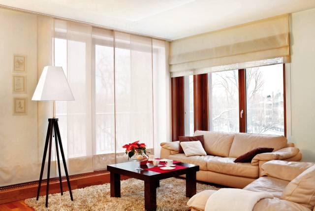 W nowocześnie urządzonych wnętrzach coraz częściej do dekoracji okien wybiera się zasłony panelowe. W tym salonie wykonano je z przezroczystej, neutralnej w kolorze tkaniny, dzięki czemu idealnie wtopiły się w wystrój pokoju i podkreśliły charakter aranżacji. <BR />DEKORACJE - OKNA DYSKRETNIE PRZESŁONIĘTE. Jedno okno przesłonięto szeroką roletą rzymską, drugie - zasłonami panelowymi z tej samej tkaniny. Panele to rozwiązanie będące połączeniem tradycyjnych zasłon (tyle, że nie są marszczone) oraz rolet (ale nie podnoszonych, lecz przesuwanych na boki).