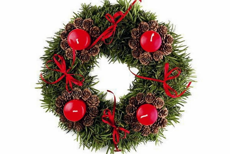 Ozdoby adwentowe. Wieniec ze świecami w kryzach z szyszek i cienkimi czerwonymi kokardkami.