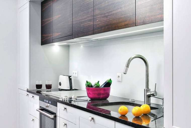 WNĘTRZE 2. Uważny obserwator dostrzeże, że wyglądające nowocześnie kuchenne szafki mają stylowe elementy - wgłębienia na frontach imitujące płyciny oraz 'spękane' gałki ceramiczne w postarzanej metalowej oprawie.